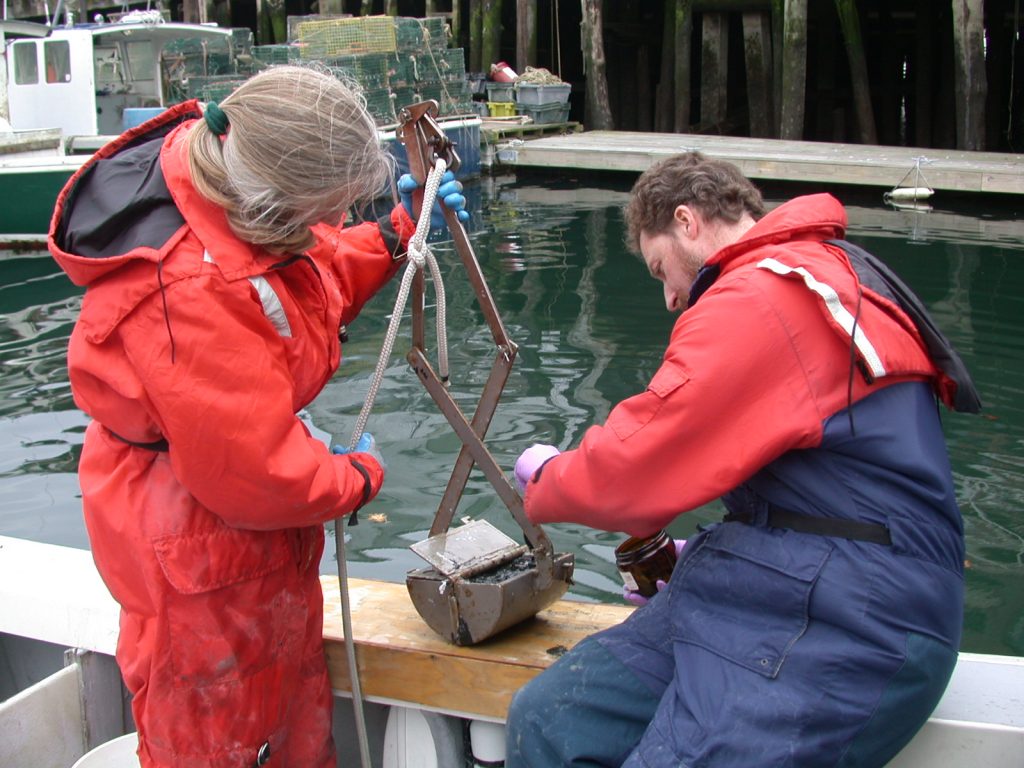 Scooping mud to test for toxins
