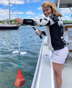 Ivy lowers the Secchi disk from the boat