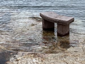 stone bench surrounded by water
