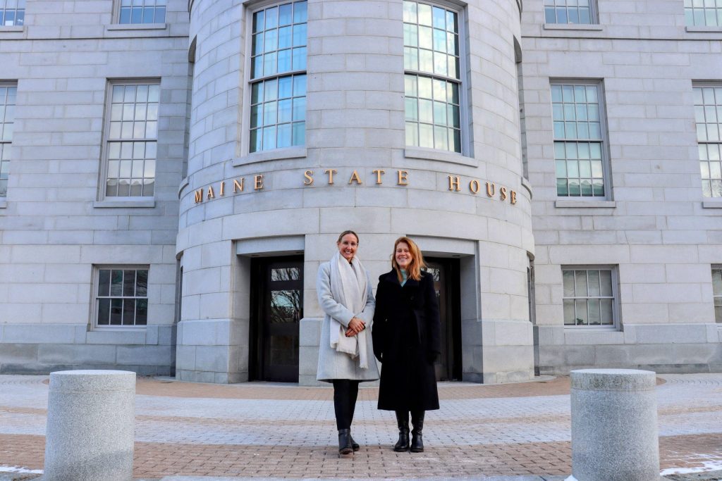 Heather and Ivy stand in front of the Maine State House.